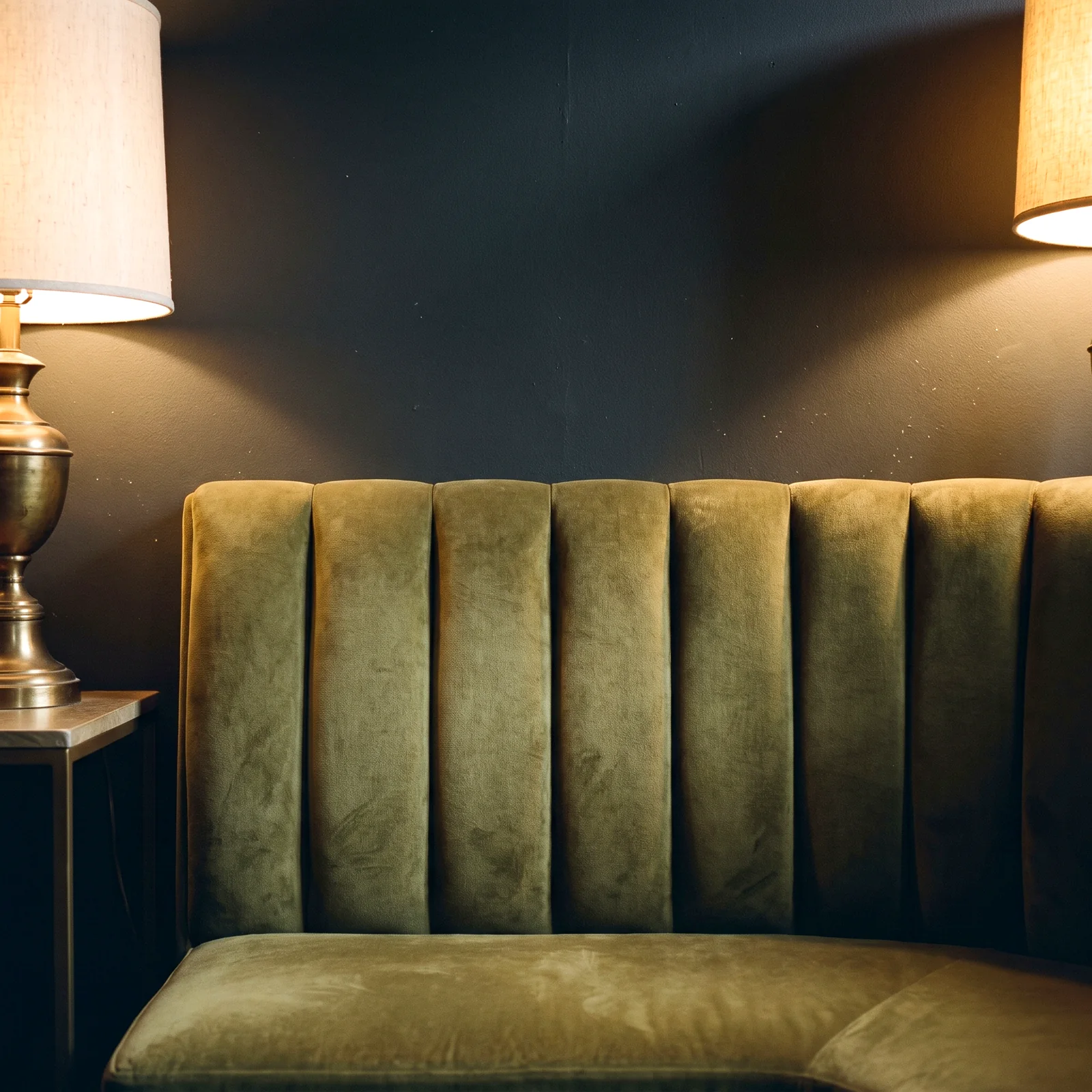 An olive velvet channel-back booth
