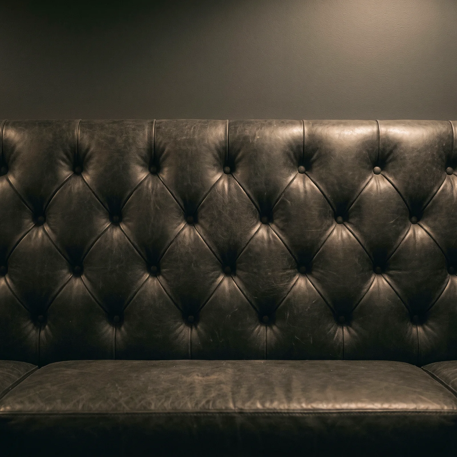 A black leather diamond-tufted booth back