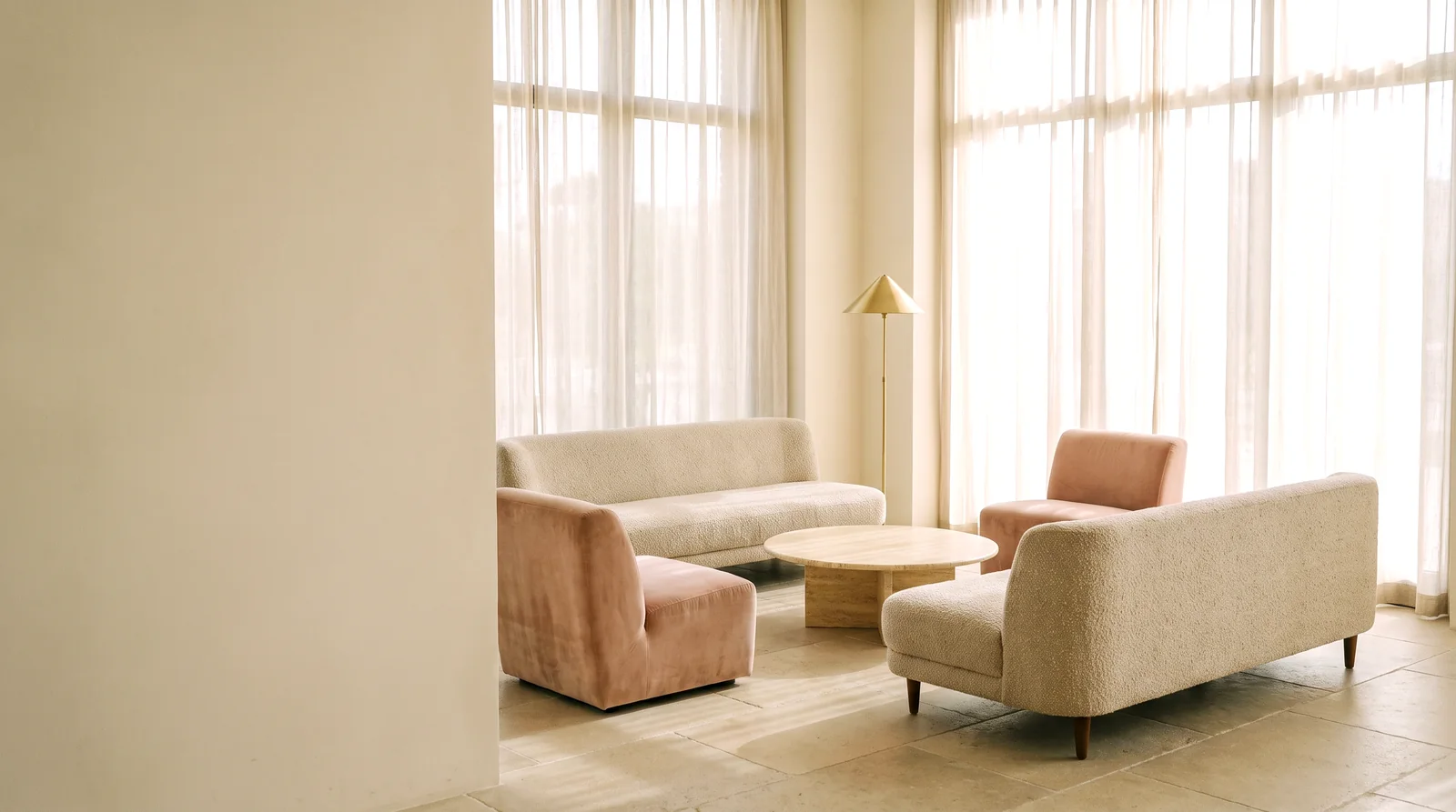 A low sectional in oatmeal boucle in a bright lobby lounge at dusk